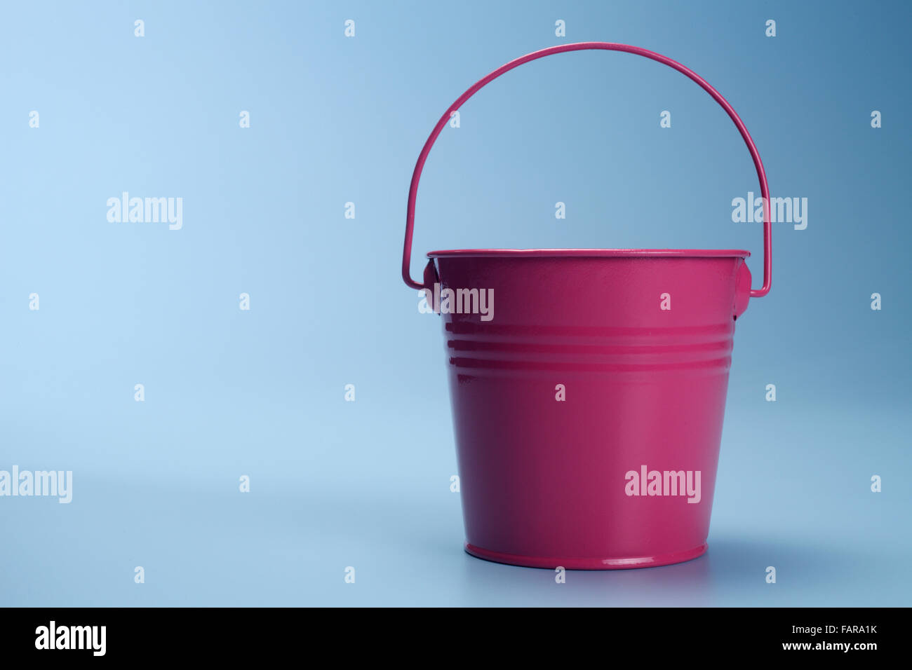 Dark red bucket isolated on the blue background Stock Photo - Alamy