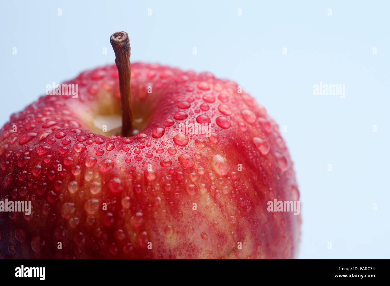 Wet red apple isolated on coloured background Stock Photo - Alamy