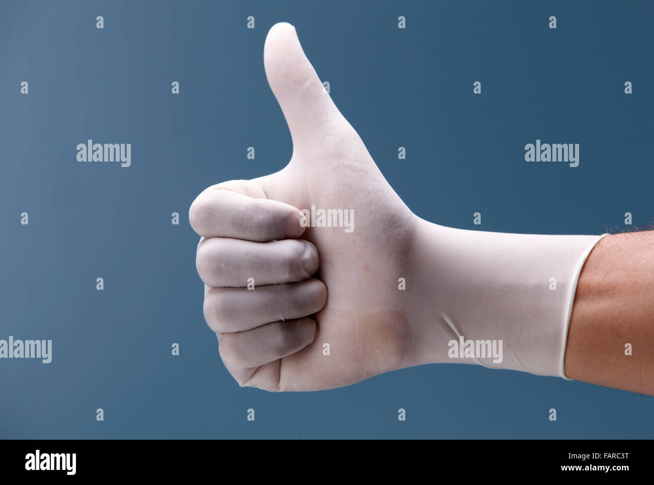 Hand shows the gesture on a coloured background. Stock Photo