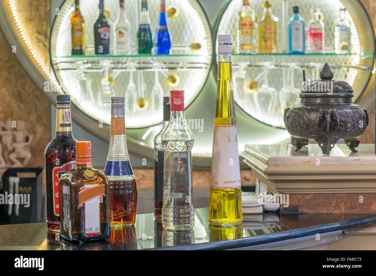 Alcohol bottles set in counter at bar Stock Photo