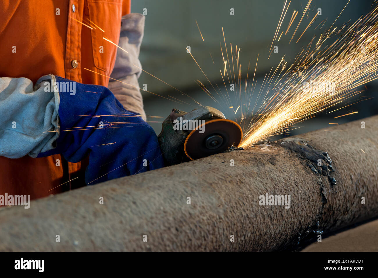 Worker cutting metal with grinder. Sparks while grinding iron Stock Photo