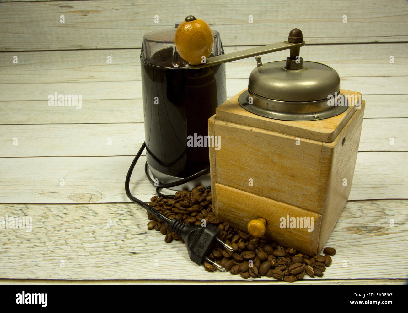 Two coffee grinders, old wooden and modern electric coffee beans on