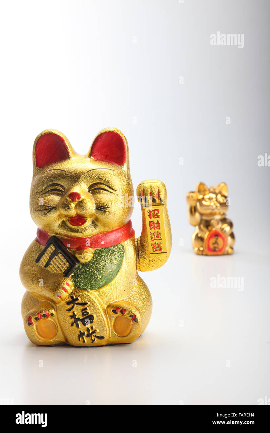Golden lucky cat on plain background Stock Photo