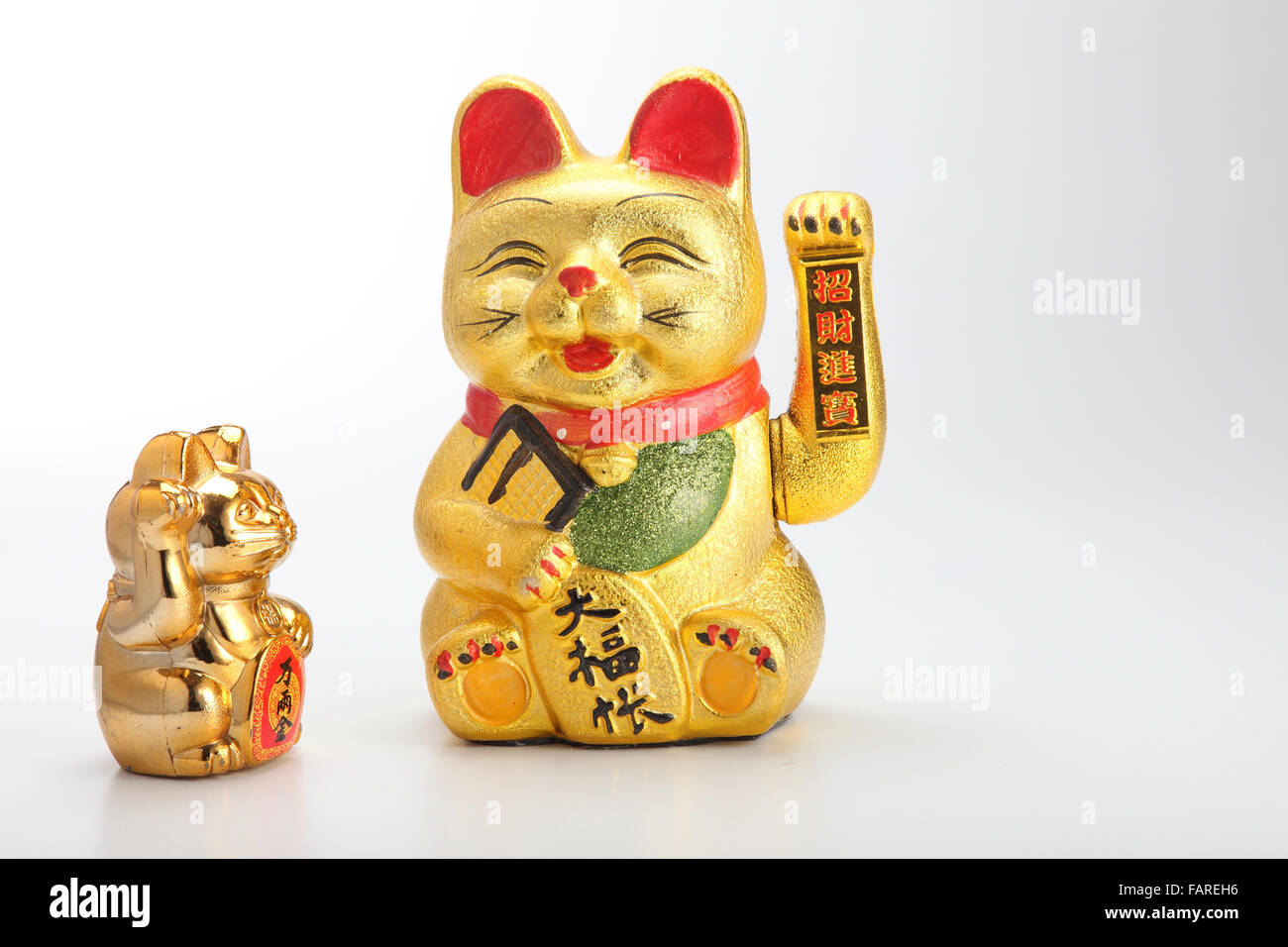 Golden lucky cat on plain background Stock Photo