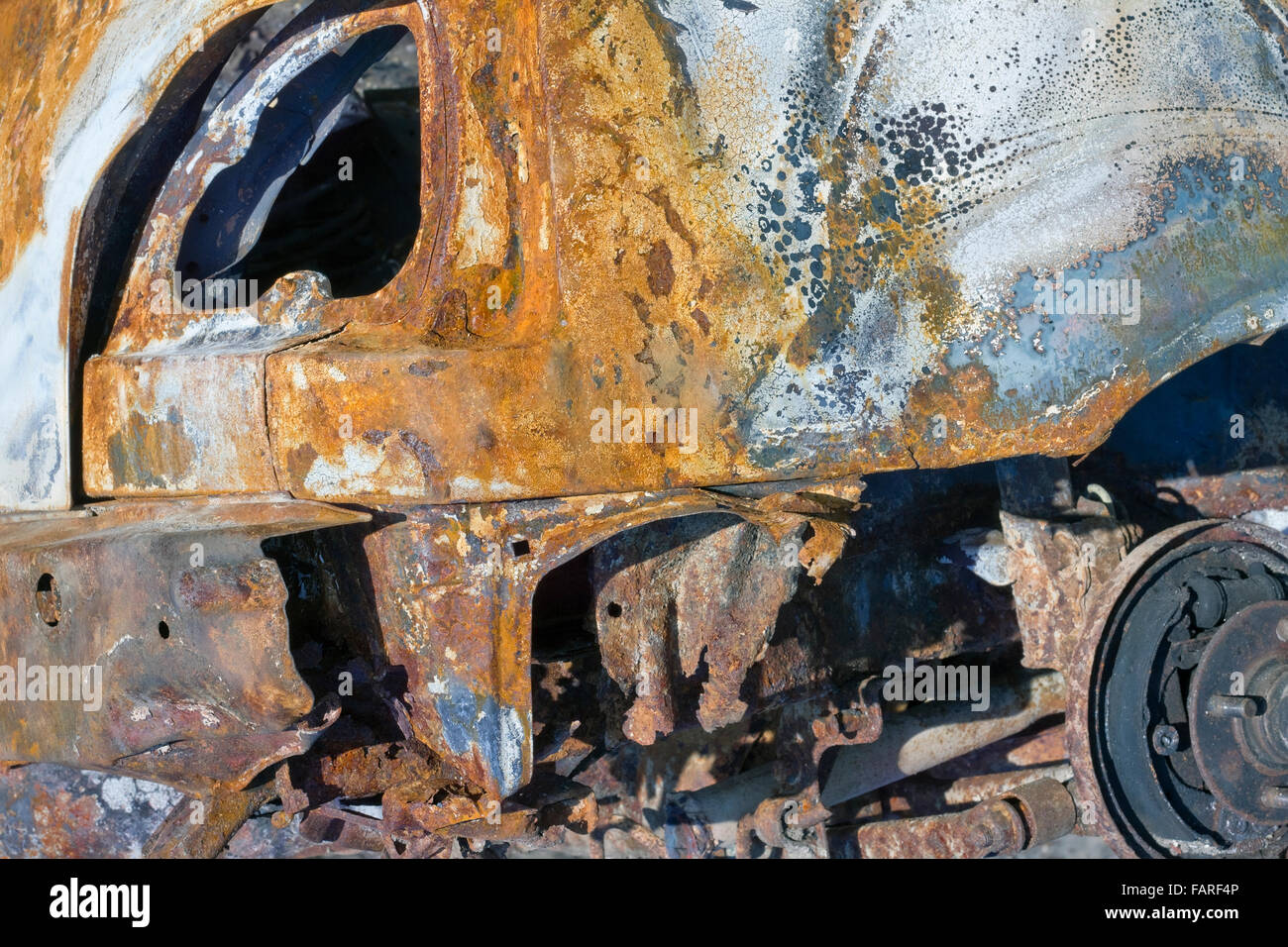 The stolen turned burned car in a ditch after accident crash background closeup Stock Photo