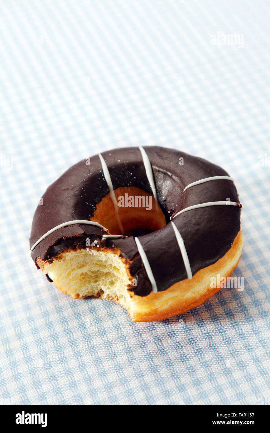 A chocolate covered doughnut with a bite taken from it Stock Photo Alamy