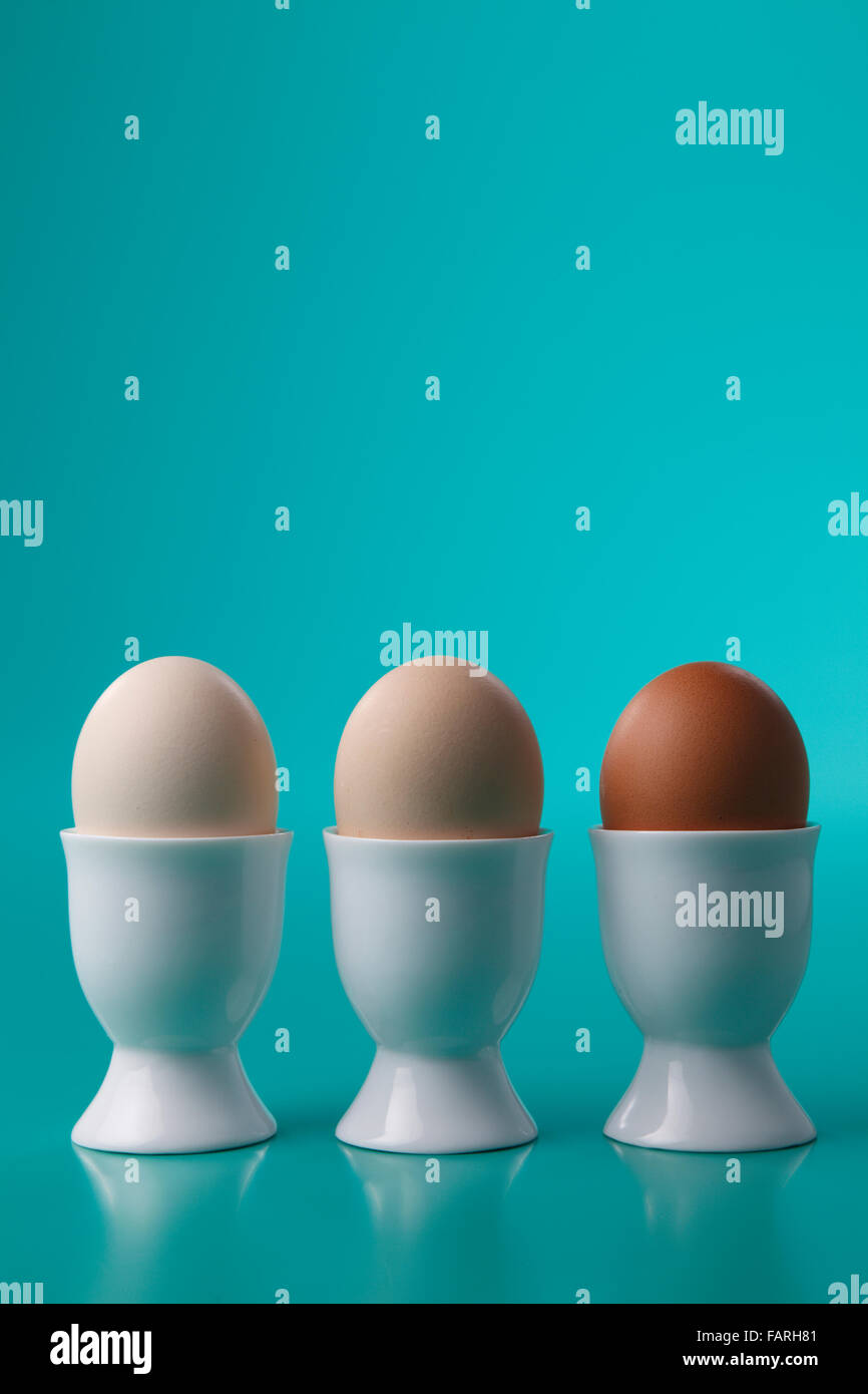 Three hard boiled eggs in porcelain egg cups Stock Photo Alamy