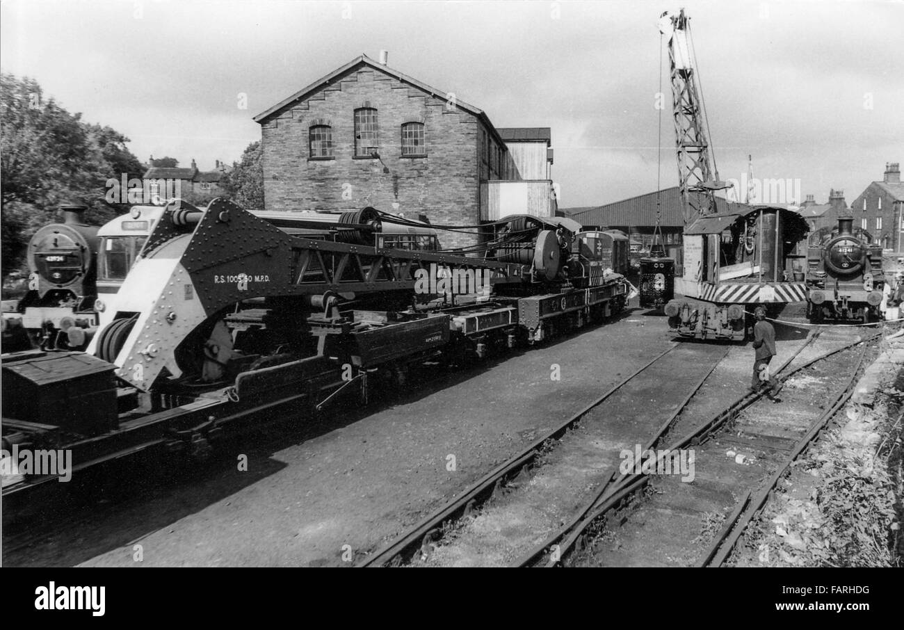 Haworth railway station, West Yorkshire circa 1982 black and white archive image. Home of the Keighley and Worth Valley Railway, the KWVR is manned by volunteers. LONDON MIDLAND & SCOTTISH IVATT CLASS 2MT 2-6-2T NO. 41241, built in 1948. Seen here with two breakdown cranes one of which is lifting a boiler. Stock Photo
