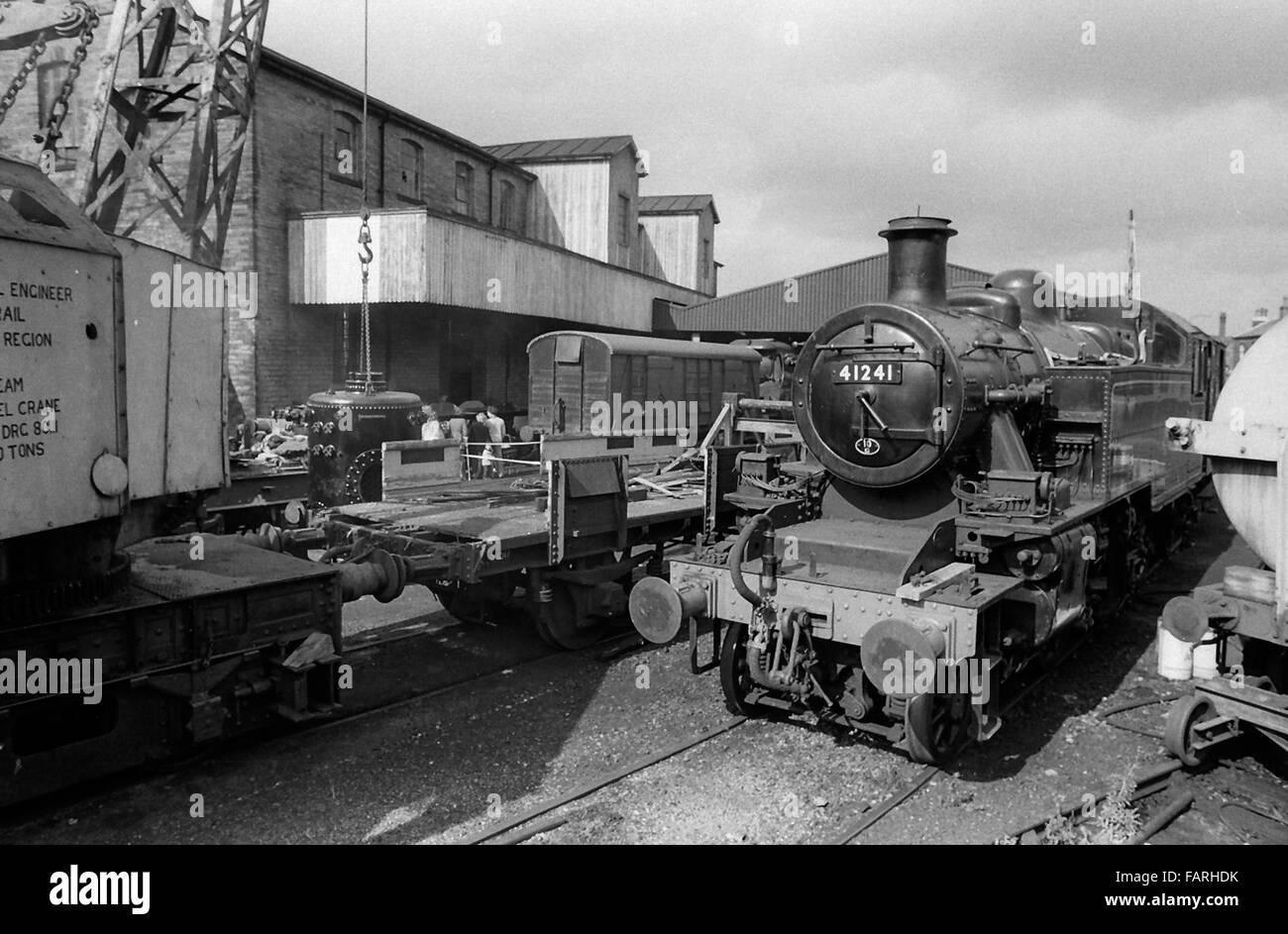 Haworth railway station, West Yorkshire circa 1982 black and white archive image. Home of the Keighley and Worth Valley Railway, the KWVR is manned by volunteers. LONDON MIDLAND & SCOTTISH IVATT CLASS 2MT 2-6-2T NO. 41241, built in 1948. Recovery crane also visible. Stock Photo