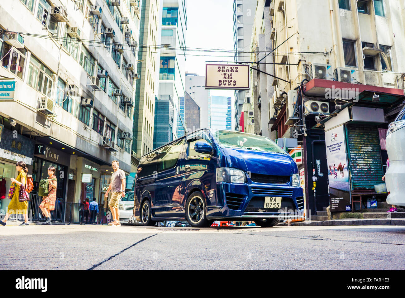 A busy Hong Kong street scene featuring a customized minivan Stock Photo
