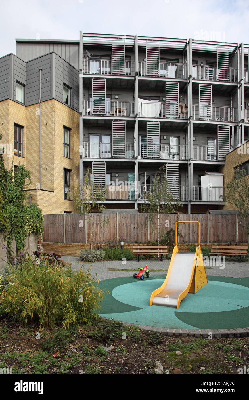 A small garden and children's play area behind a new block of flats in