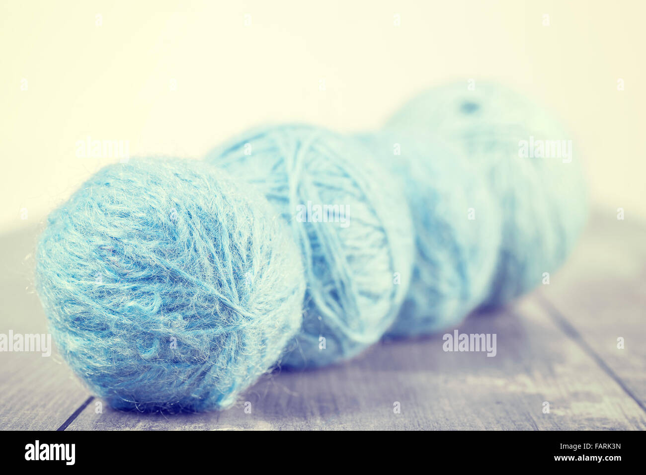 Vintage toned wool balls on a wooden background, shallow depth of field. Stock Photo