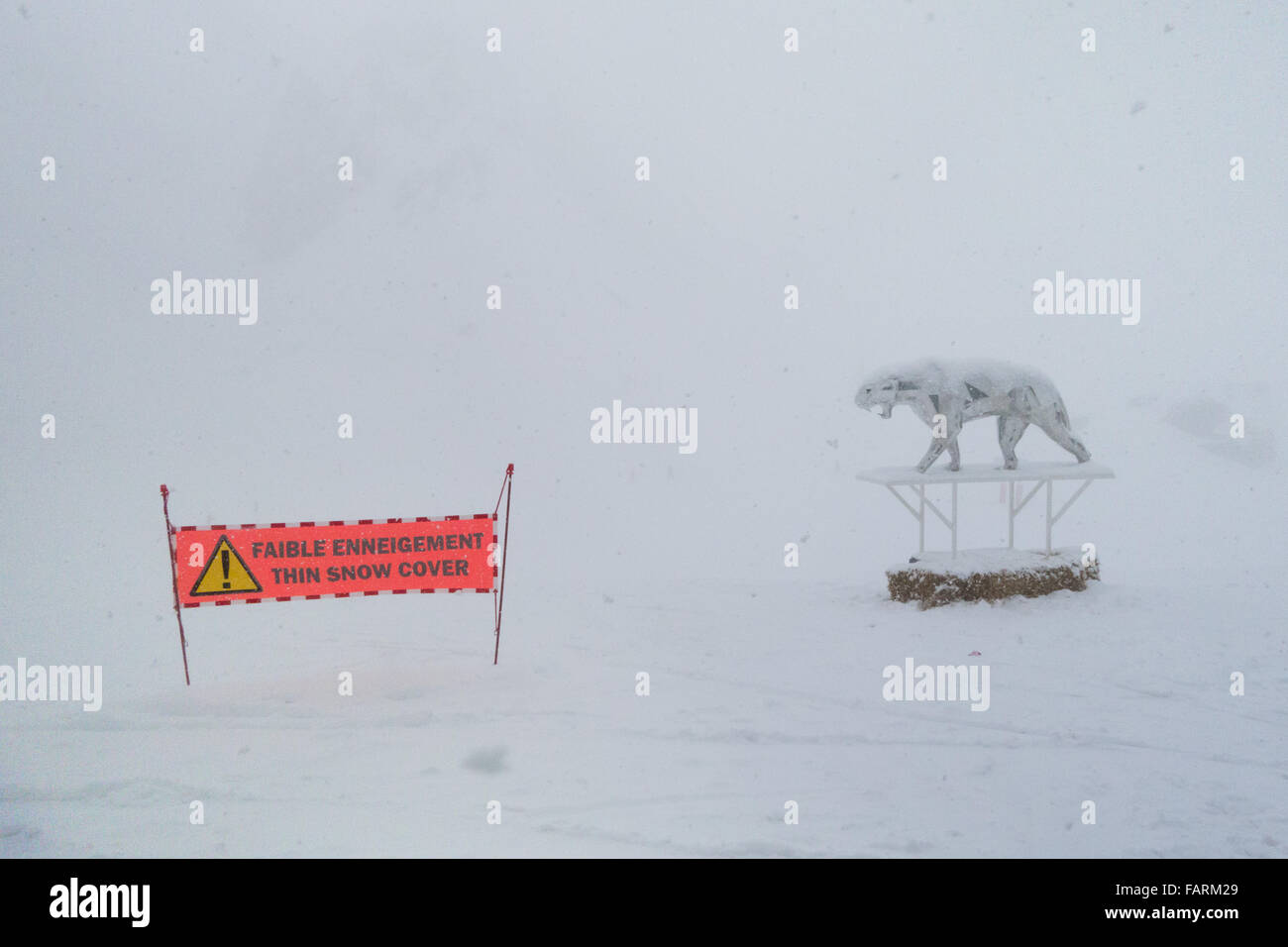 Courchevel, France - thin snow cover sign next to Orlinski summit sculpture in much needed falling snow Stock Photo