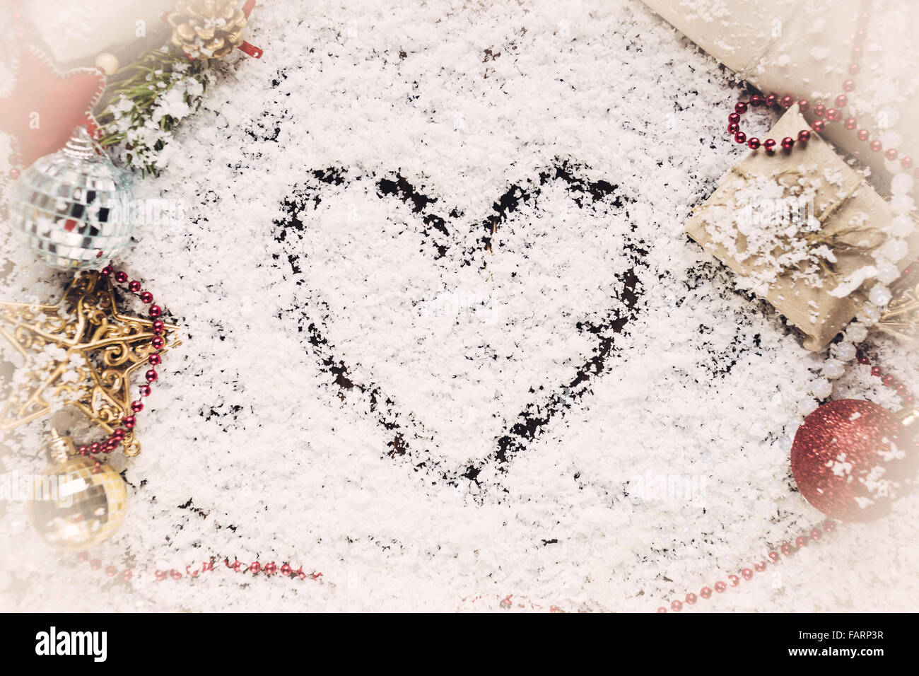 Heart drawn on the snow with gifts Stock Photo - Alamy