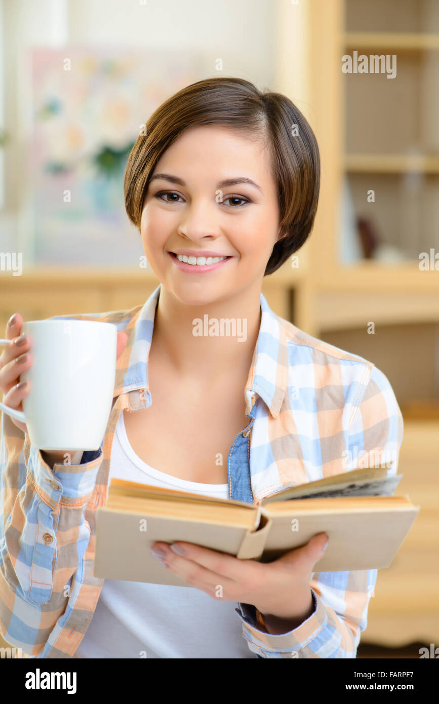 Teenage girl is drinking tea and reading Stock Photo Alamy