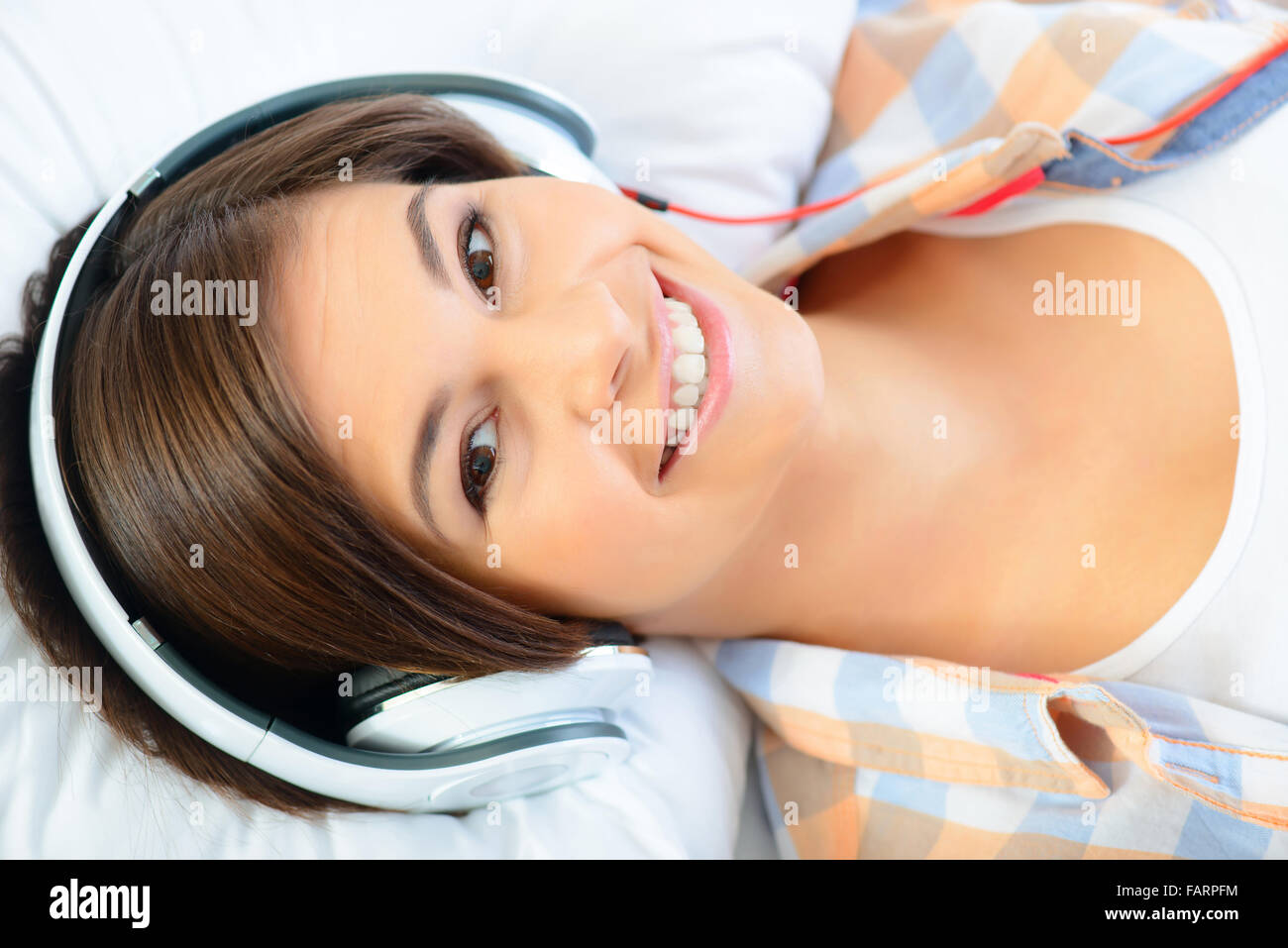 Teenage girl lying in bed and listening to music Stock Photo - Alamy
