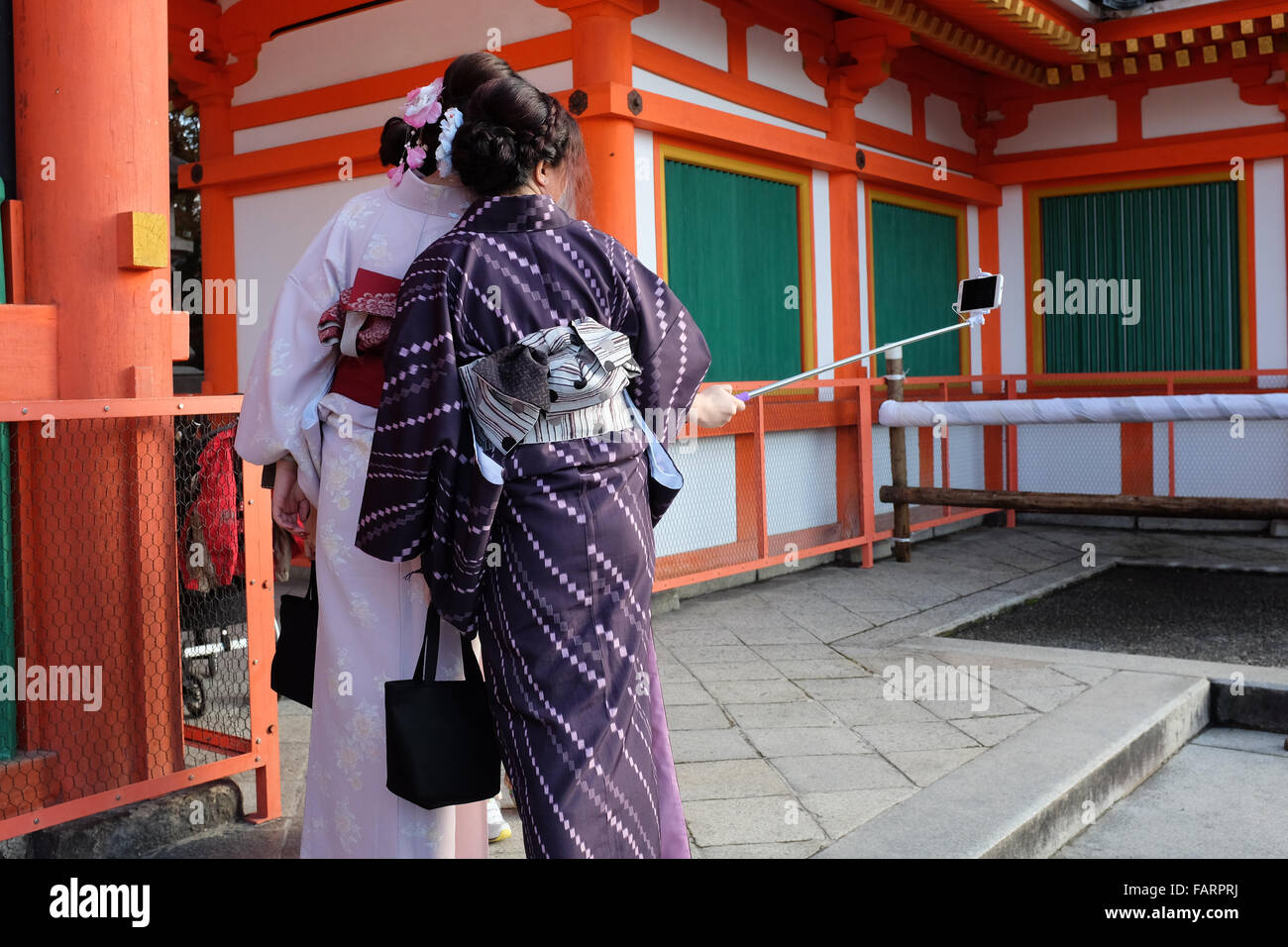 Two women in Japan taking a photo using a smartphone and selfie stick. Stock Photo