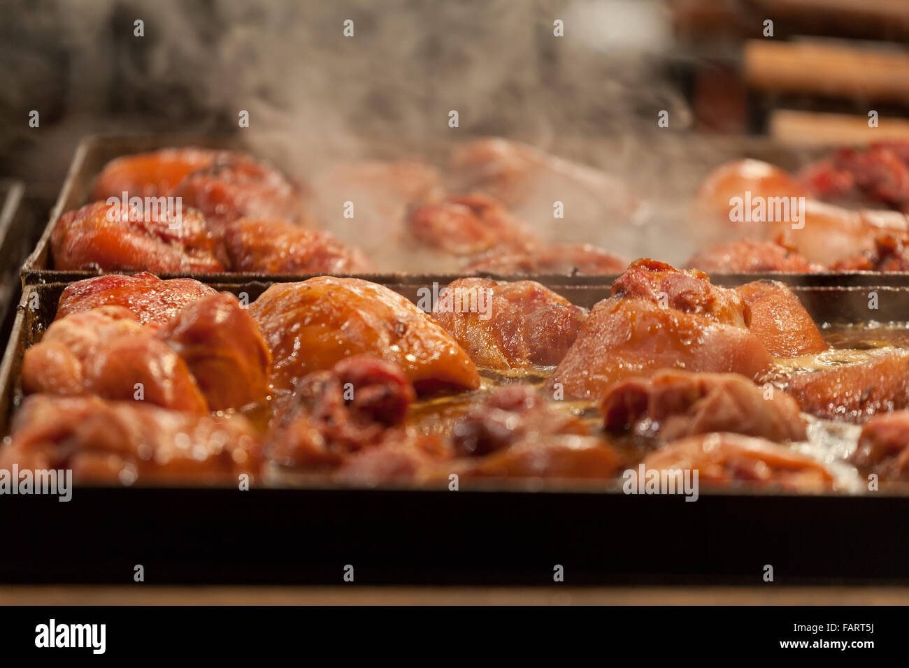 Meat is fried on a big frying pan at street fair Stock Photo