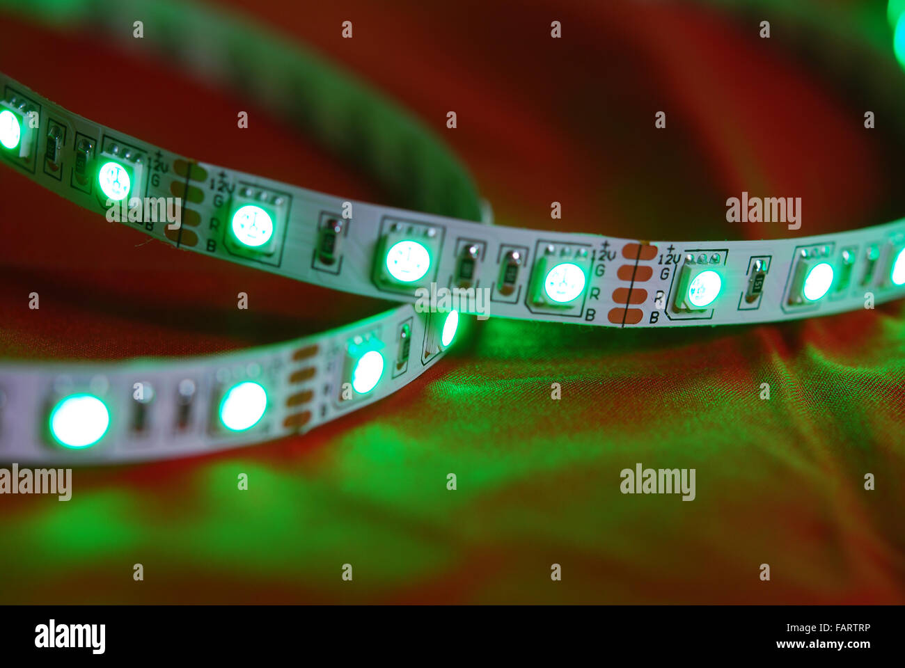 Green led strip on the background of red textile Stock Photo - Alamy