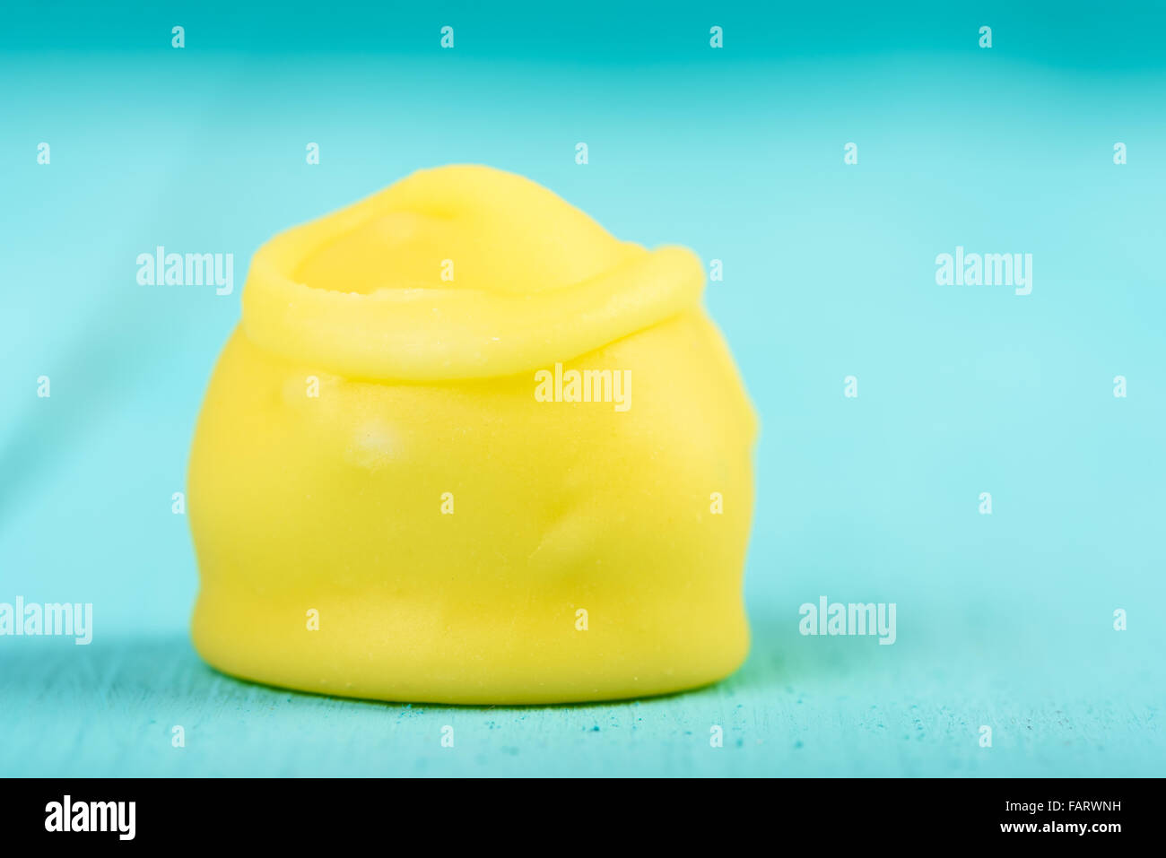 Yellow Fondant Candy On Turquoise Background Stock Photo