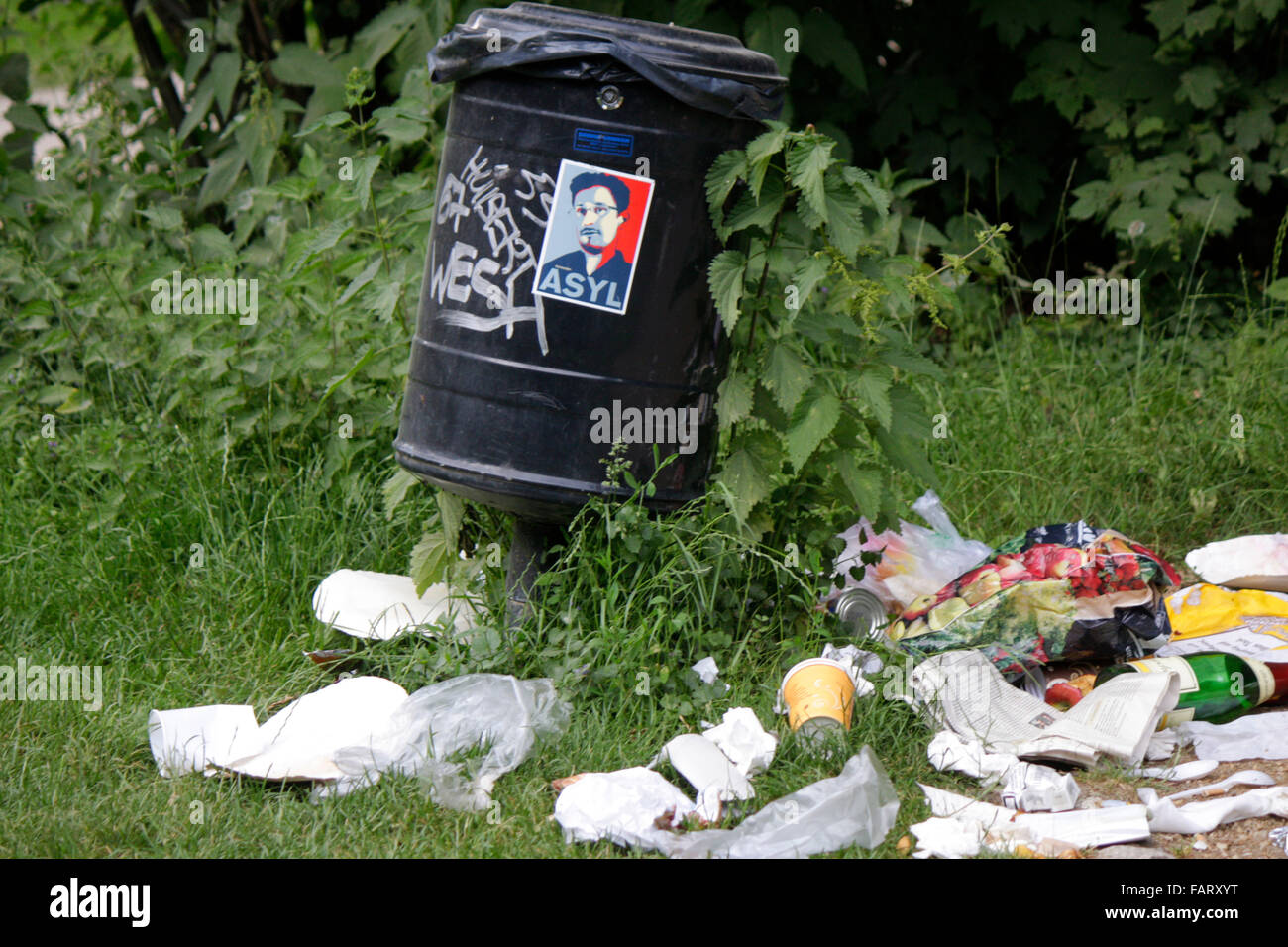 ueberfuellte Muelltonne mit Aufkleber mit dem Portrait von Edward Snowden, Berlin-Tiergarten. Stock Photo