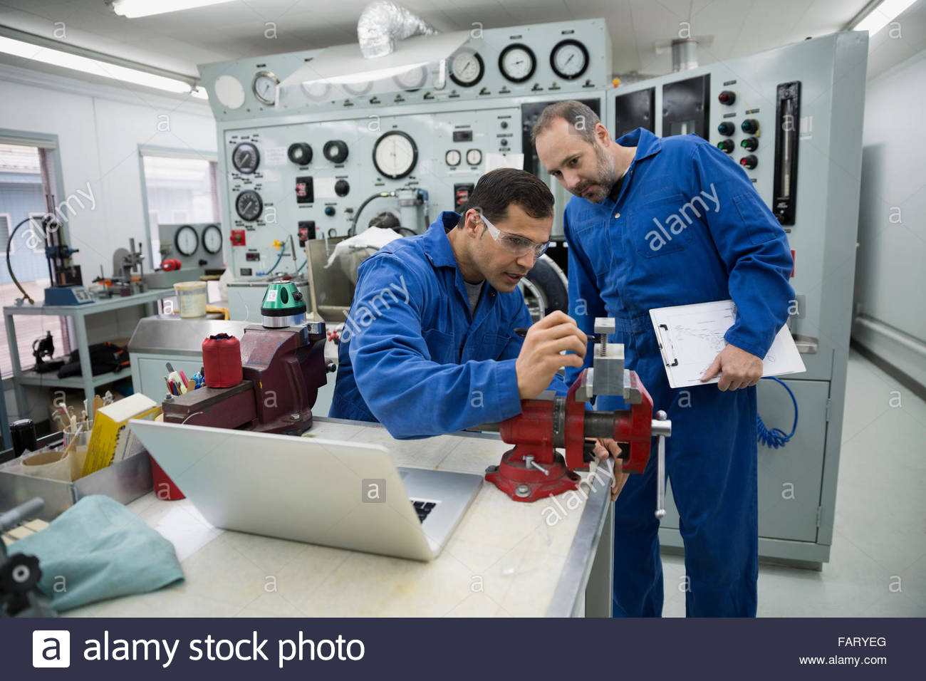 Helicopter mechanics using vise grip in workshop Stock Photo