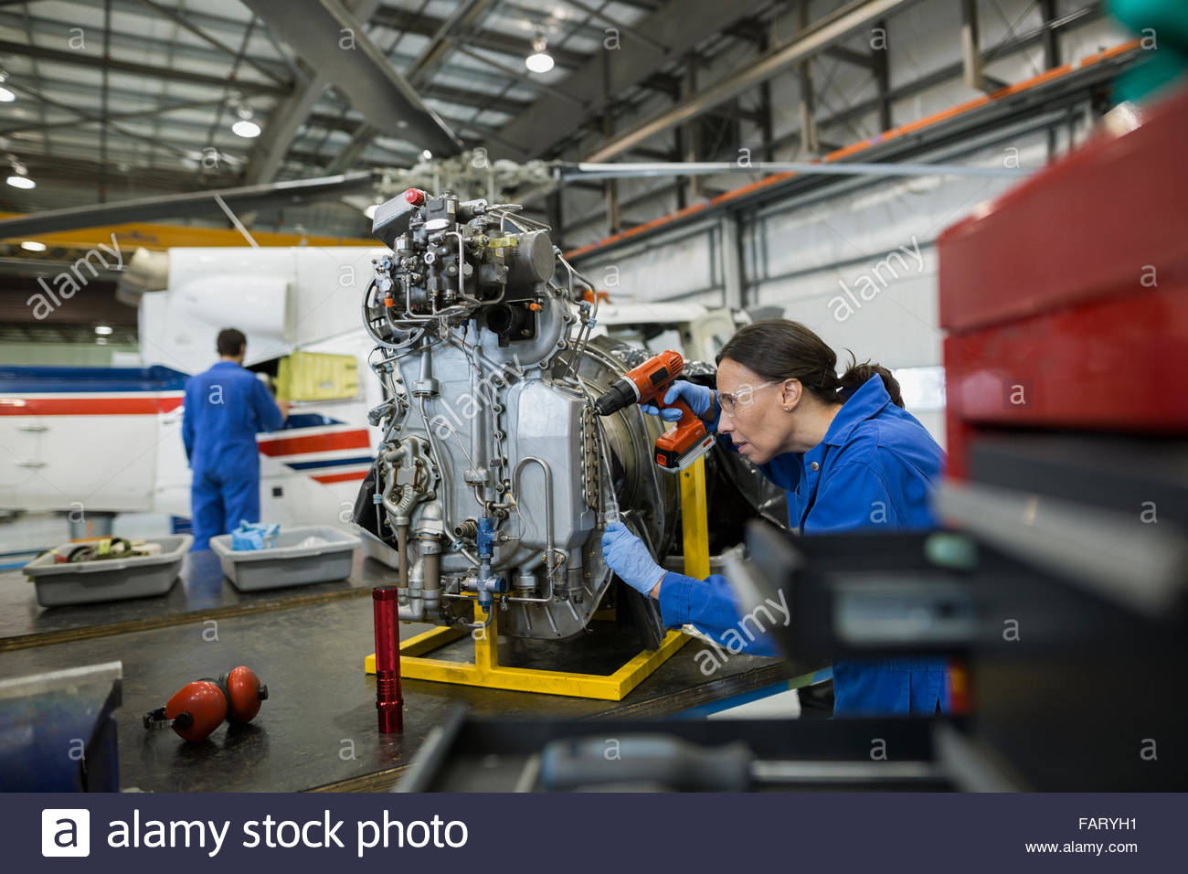 Mechanic using drill on helicopter part airplane hangar Stock Photo Alamy