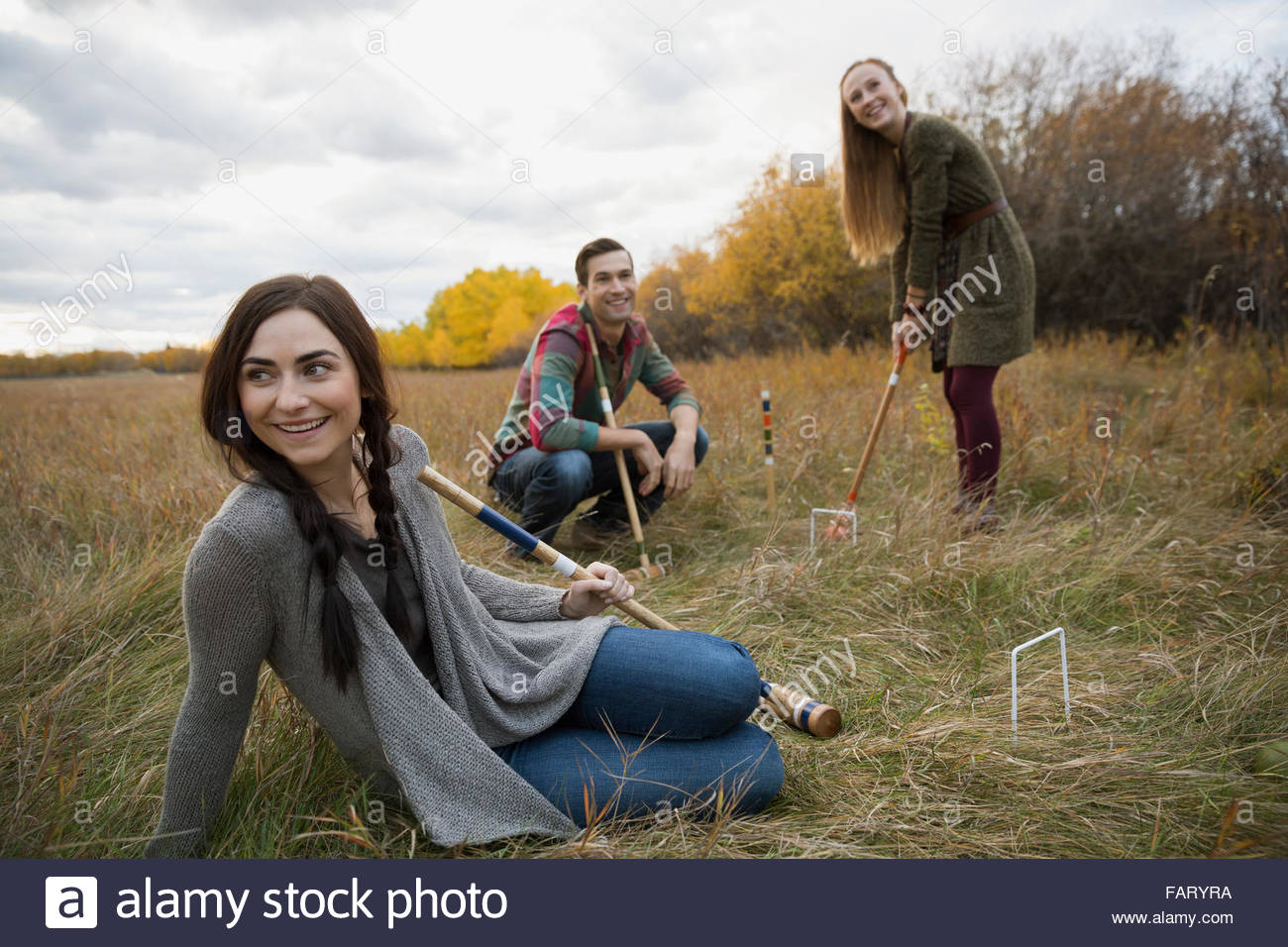 Friends playing croquet in field Stock Photo Alamy
