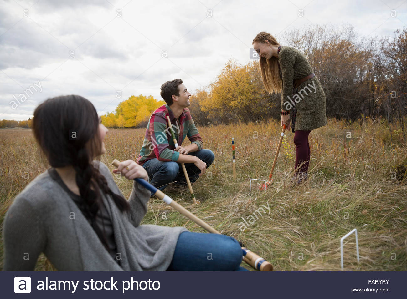 Friends playing croquet in field Stock Photo Alamy