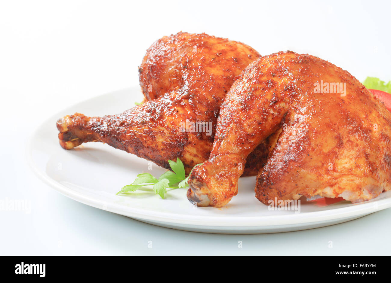 Two garlic roasted chicken leg quarters on plate Stock Photo 92725240