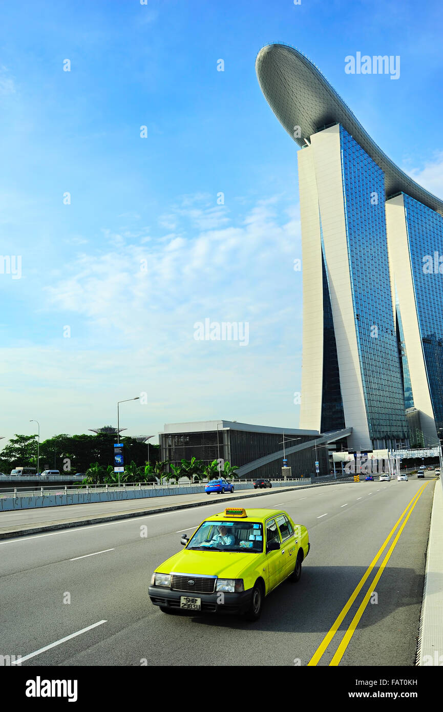 Taxi cab driving by the road in front of Marina Bay Sands hotel in Singapore. The government will spen Stock Photo