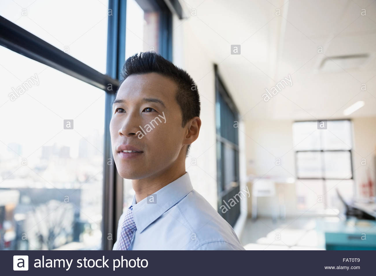Pensive businessman looking out office window Stock Photo Alamy
