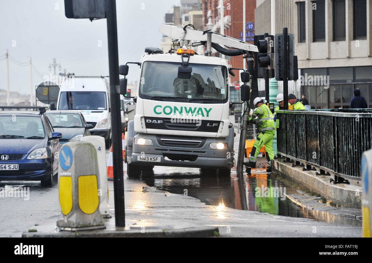 Brighton Sussex UK 4th January 2016  - Workmen pump away flood water as the roadworks started today on the A259 seafront road by the junction of West Street . The work will also involve the restoration of the seafront shelter hall Photograph taken by Simon Dack Stock Photo
