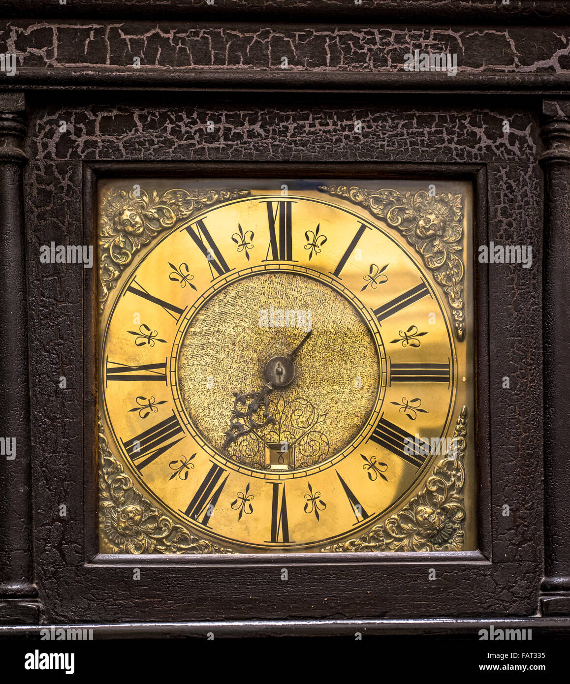 Antique grandfather clock face detail with distressed wooden casing. Stock Photo