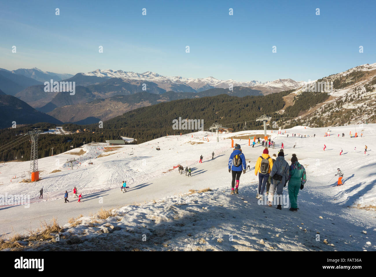Meribel, France - walkers and skiers mingle on the slopes during a period of unseasonably warm weather int he French Alps Stock Photo