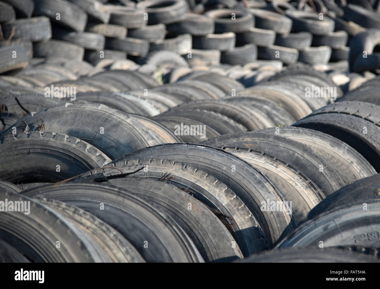 Old  used rubber tires  piled  in a recycling yard waiting to be  shredded and  re-manufactured into usable  products Stock Photo