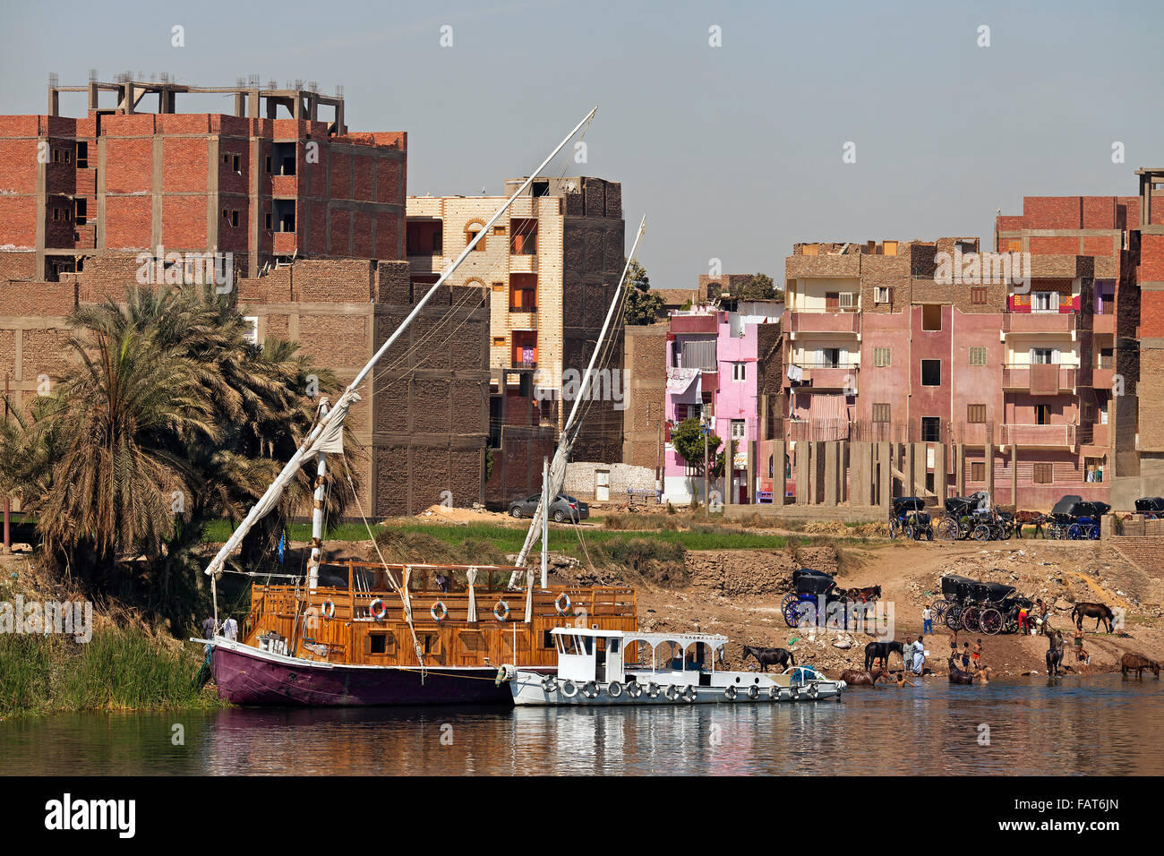 Dahabeya / Dahabiya cruise boat and the city Edfu / Idfu / Edfou on the west bank of the Nile River, Egypt Stock Photo