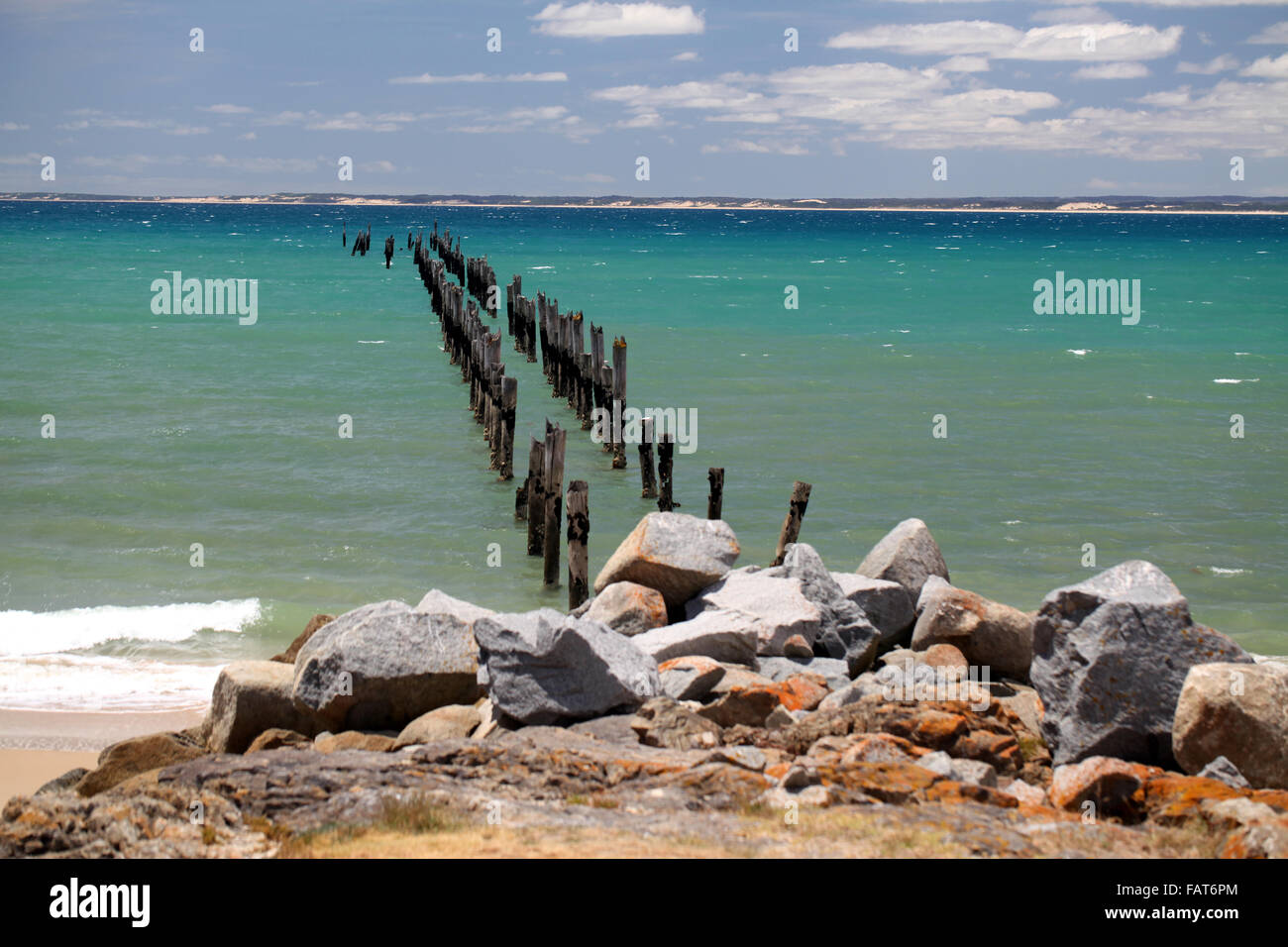 A dilapidated pier, only the posts still remaining, make their raggedy way out to sea from Bridport ,Tasmania Stock Photo