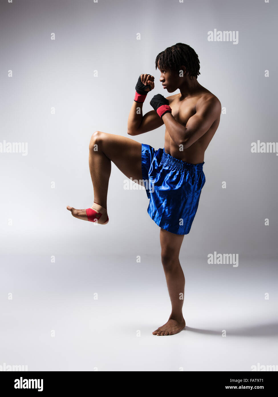 Young muscular athletic male boxer wearing blue boxing shorts and red