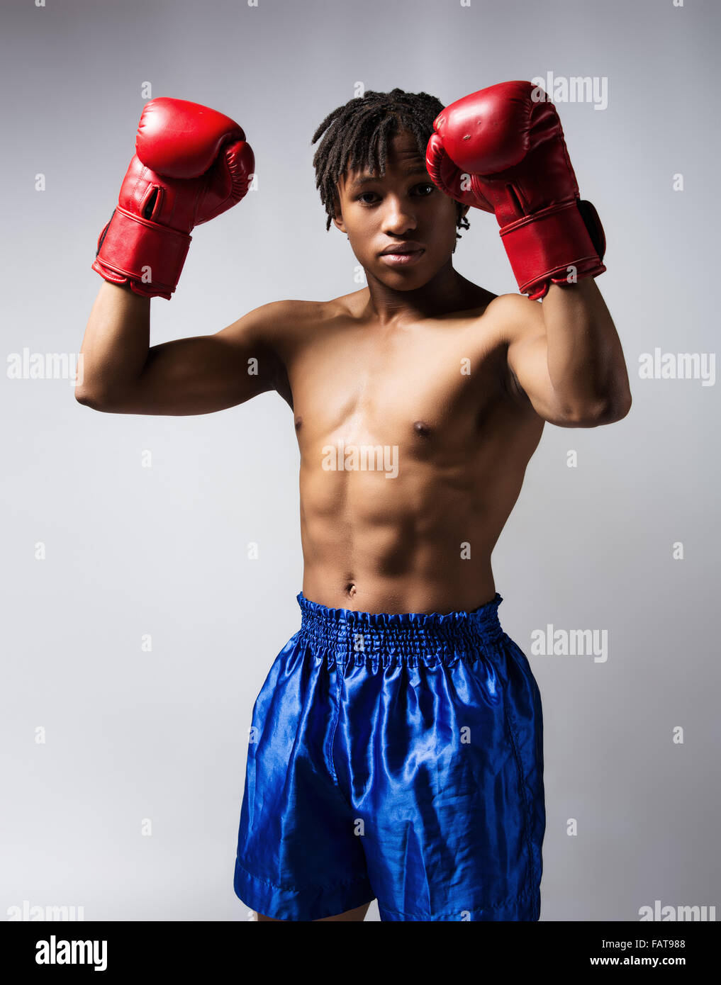 Young muscular athletic male boxer wearing blue boxing shorts and