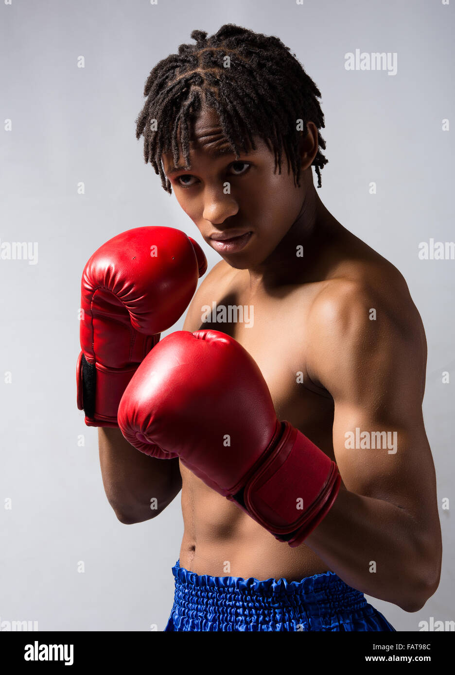 Young muscular athletic male boxer wearing blue boxing shorts and