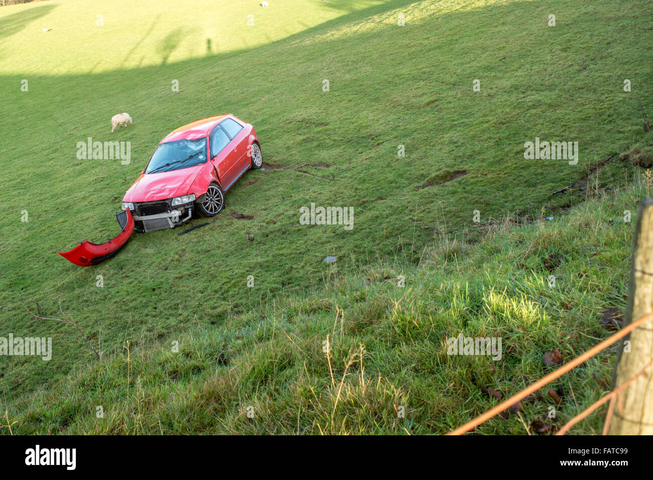 damaged red Audi thats gone off the road into a field Stock Photo