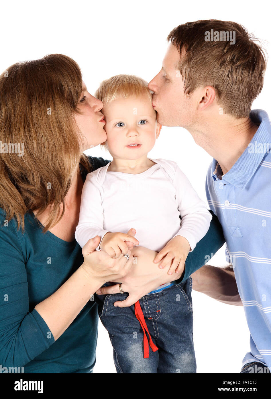 Caucasian family with mom dad and baby boy. The parents are kissing their son. Image is isolated on a white background. Stock Photo