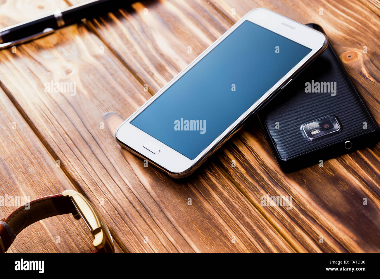 white and black mobile phones on the wooden background. Stock Photo