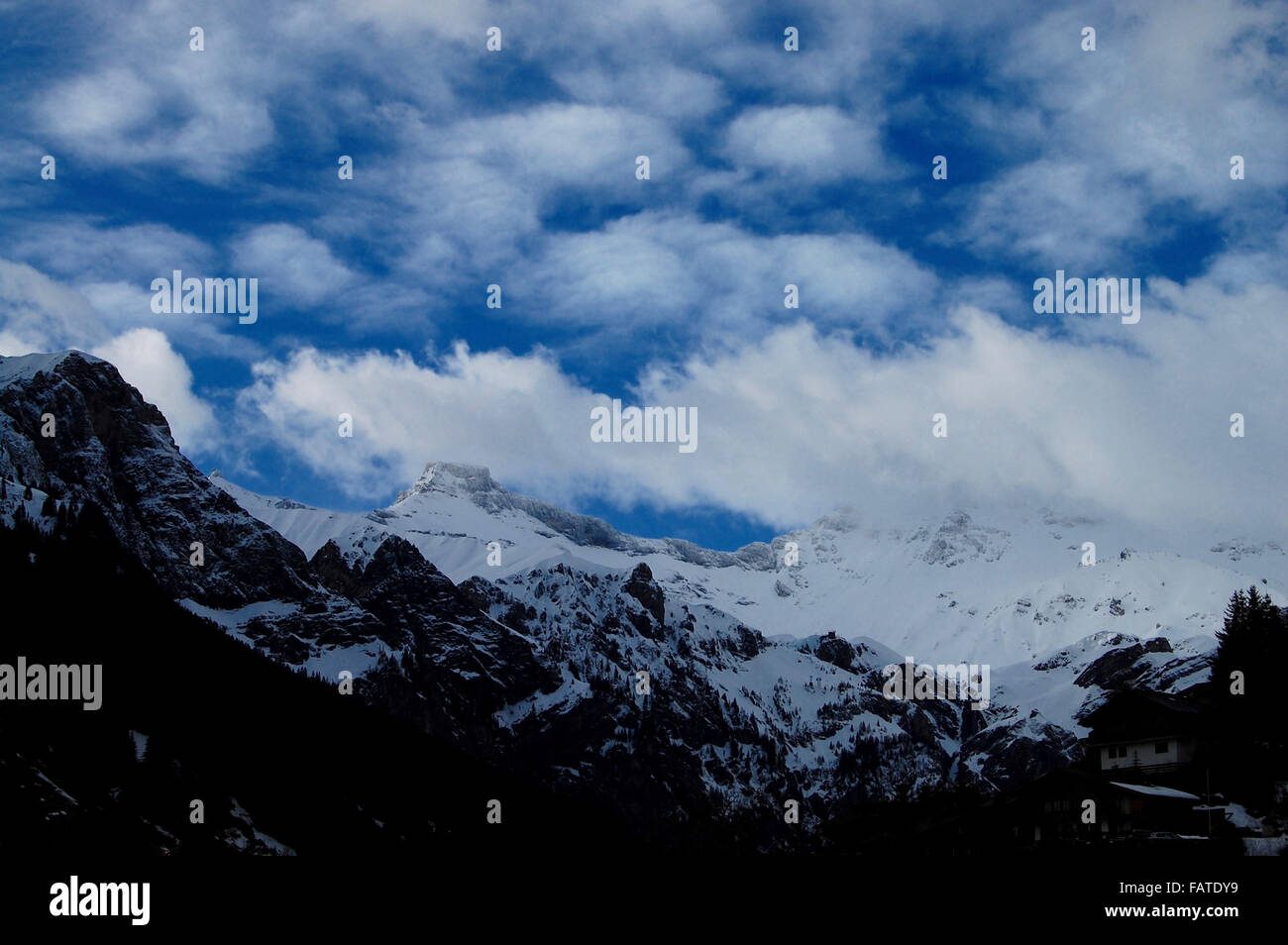 Clouds cover snow capped mountains in Switzerland Stock Photo - Alamy