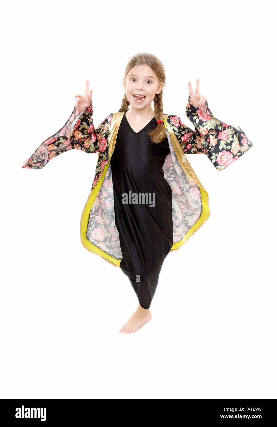 young girl playing dress up wearing a Japanese kimono and showing the victory sign on white background Stock Photo