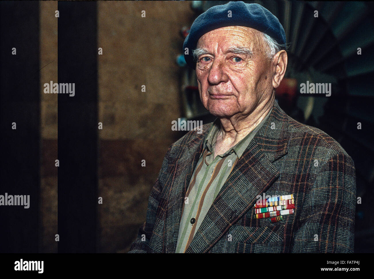 A head and shoulders portrait of a male  World War II Soviet Veteran wearing a beret and a sport coat in the Siberian region of Stock Photo