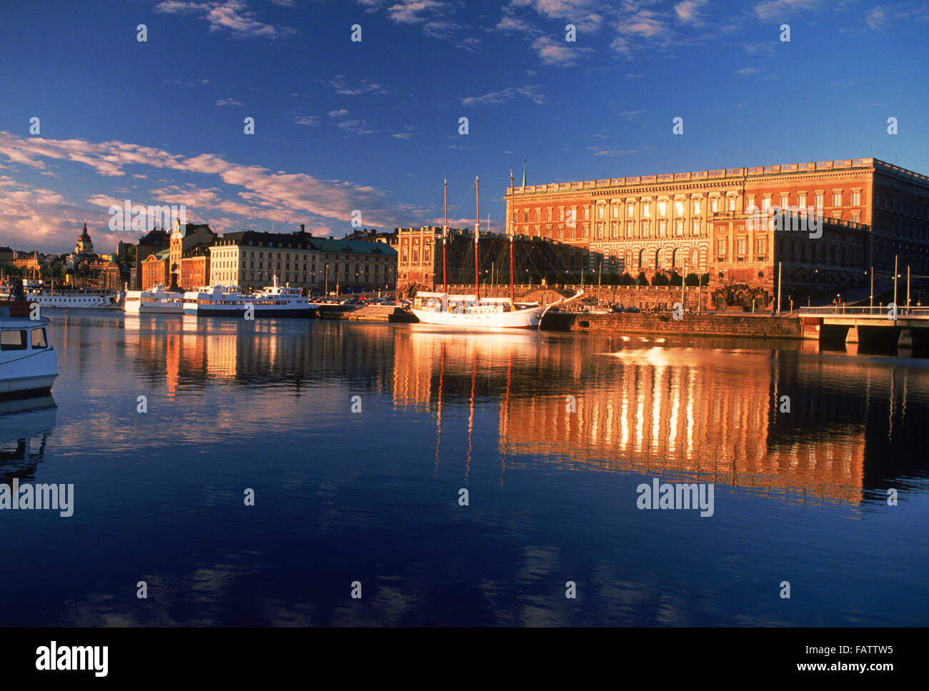 Boats anchored along Skeppsbron at sunrise with Royal Palace and Old Town in Stockholm Stock Photo