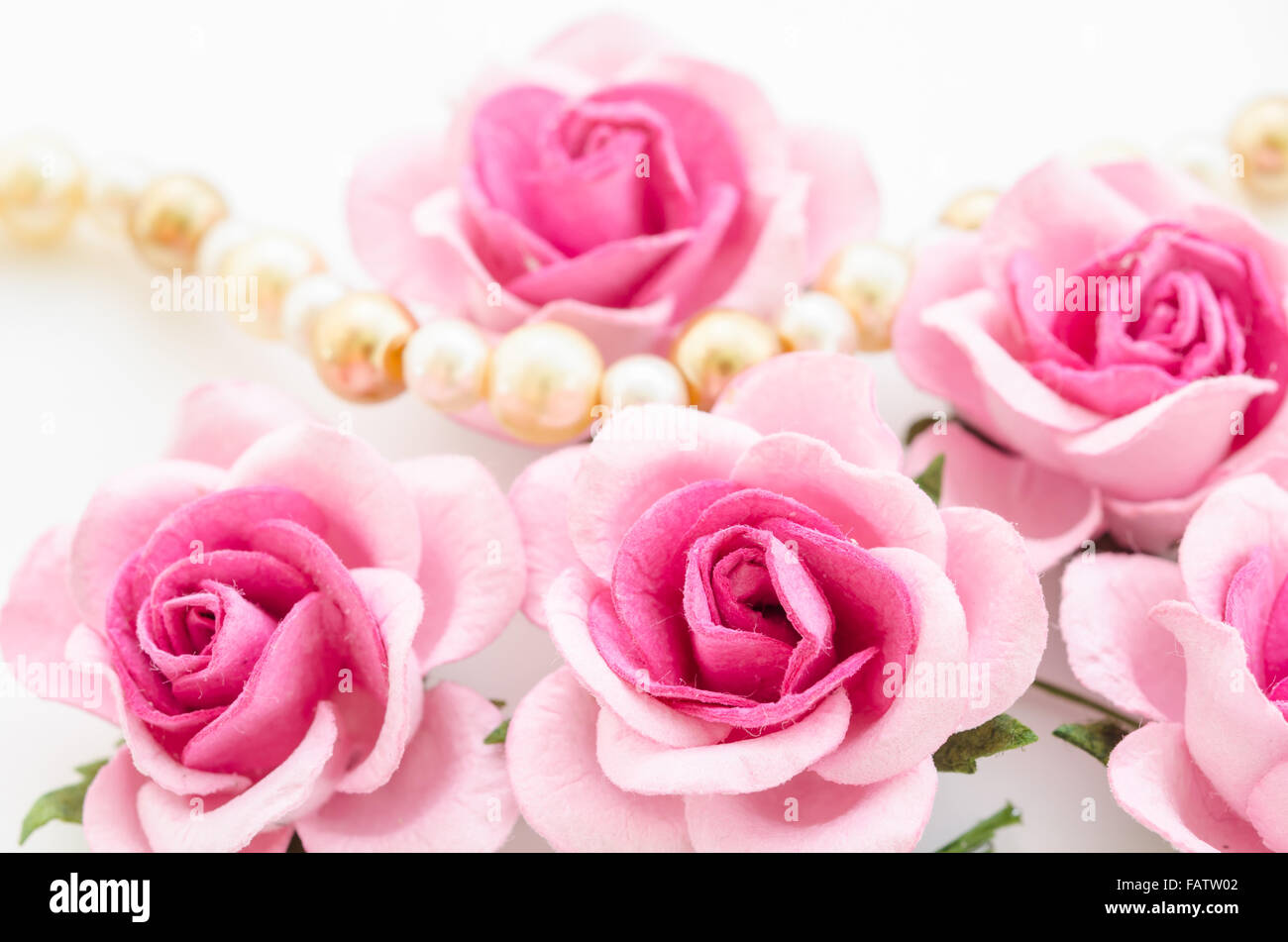 Pink rose with pearls on white background. Stock Photo