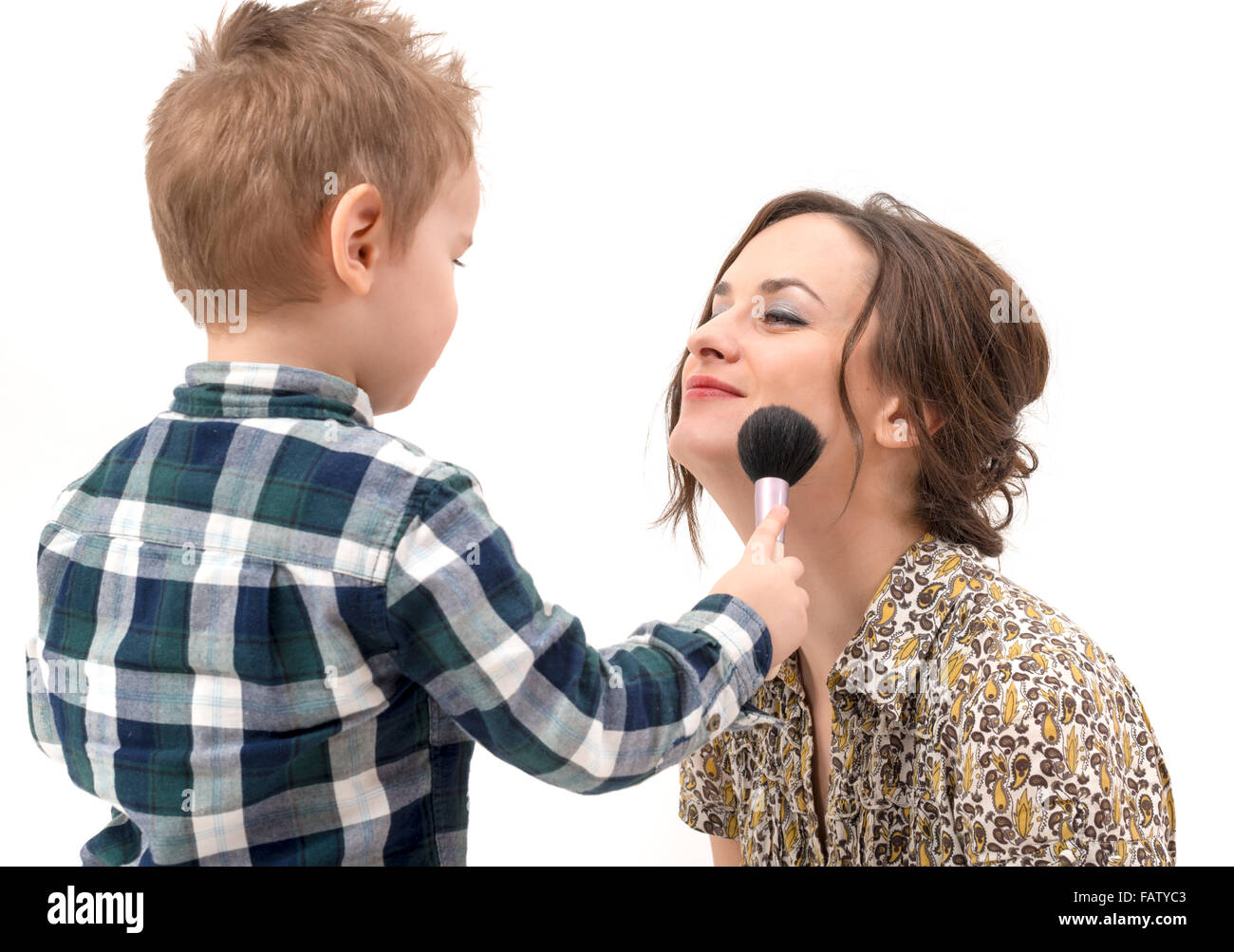 little boy putting on the makeup to her mother Stock Photo
